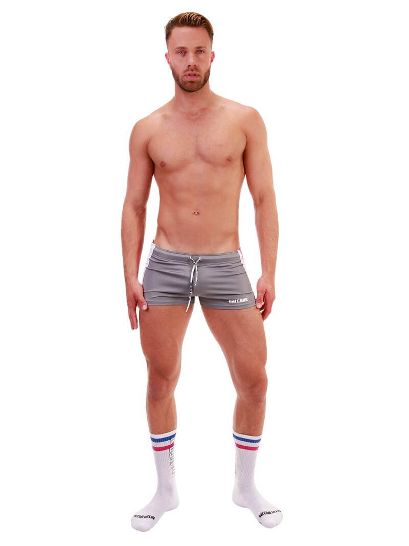 A model wearing royal blue short-legged shorts with sporty side stripes and a drawstring waist.