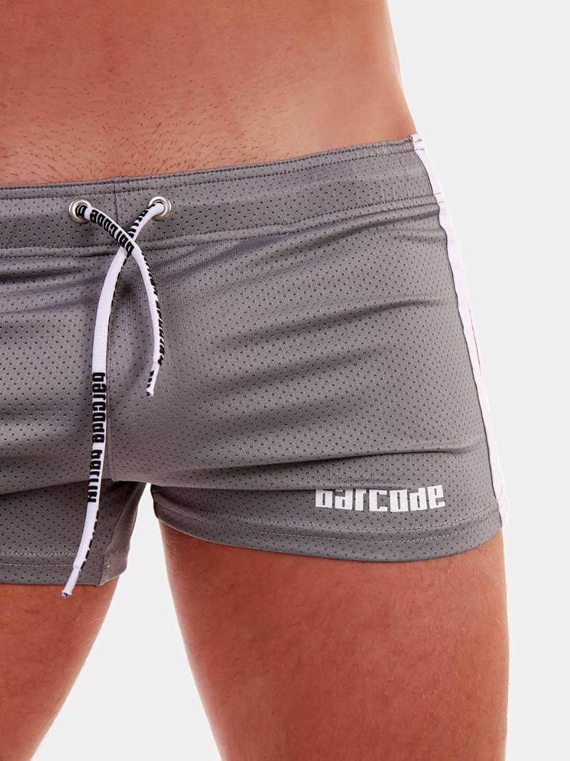 A model wearing royal blue short-legged shorts with sporty side stripes and a drawstring waist.