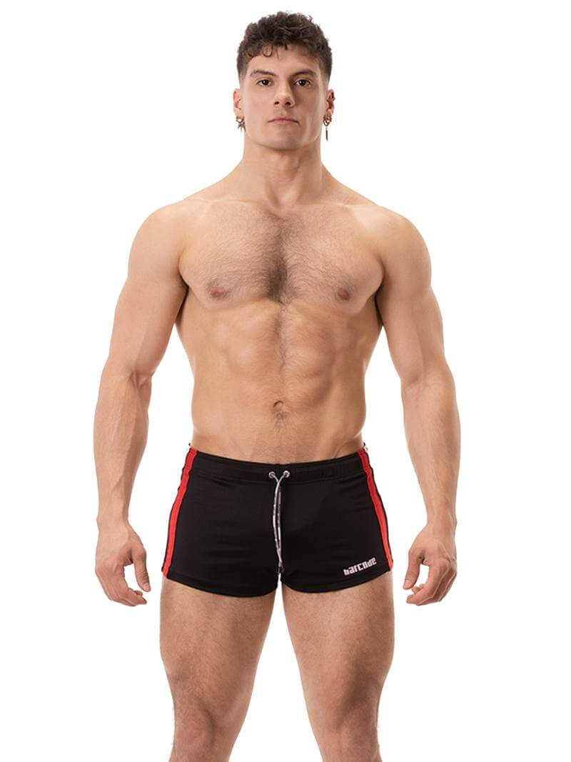 A model wearing black short-legged shorts with sporty side stripes and a drawstring waist.