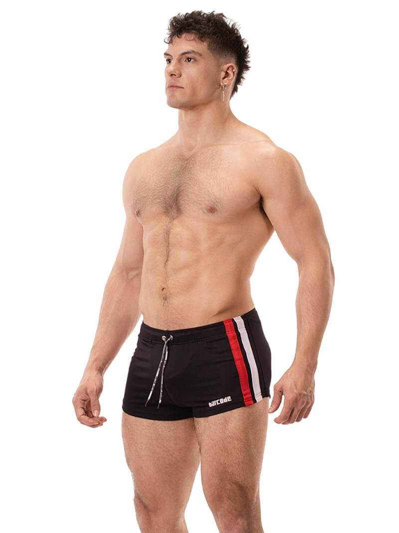 A model wearing black short-legged shorts with sporty side stripes and a drawstring waist.