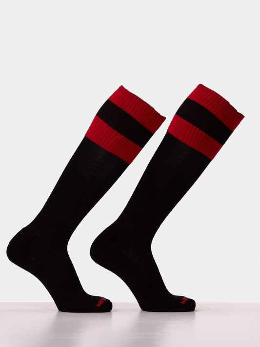 A pair of black knee-high athletic socks with bold red horizontal stripes near the ribbed cuffs, displayed on invisible forms against a clean white background.