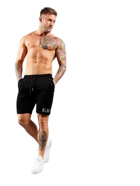 Man wearing black shorts with 'BLAK' branding on a white background