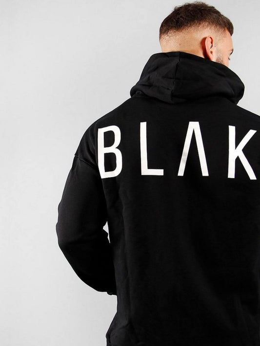 Person wearing a black hoodie with 'BLAK' printed on the back against a light gray background