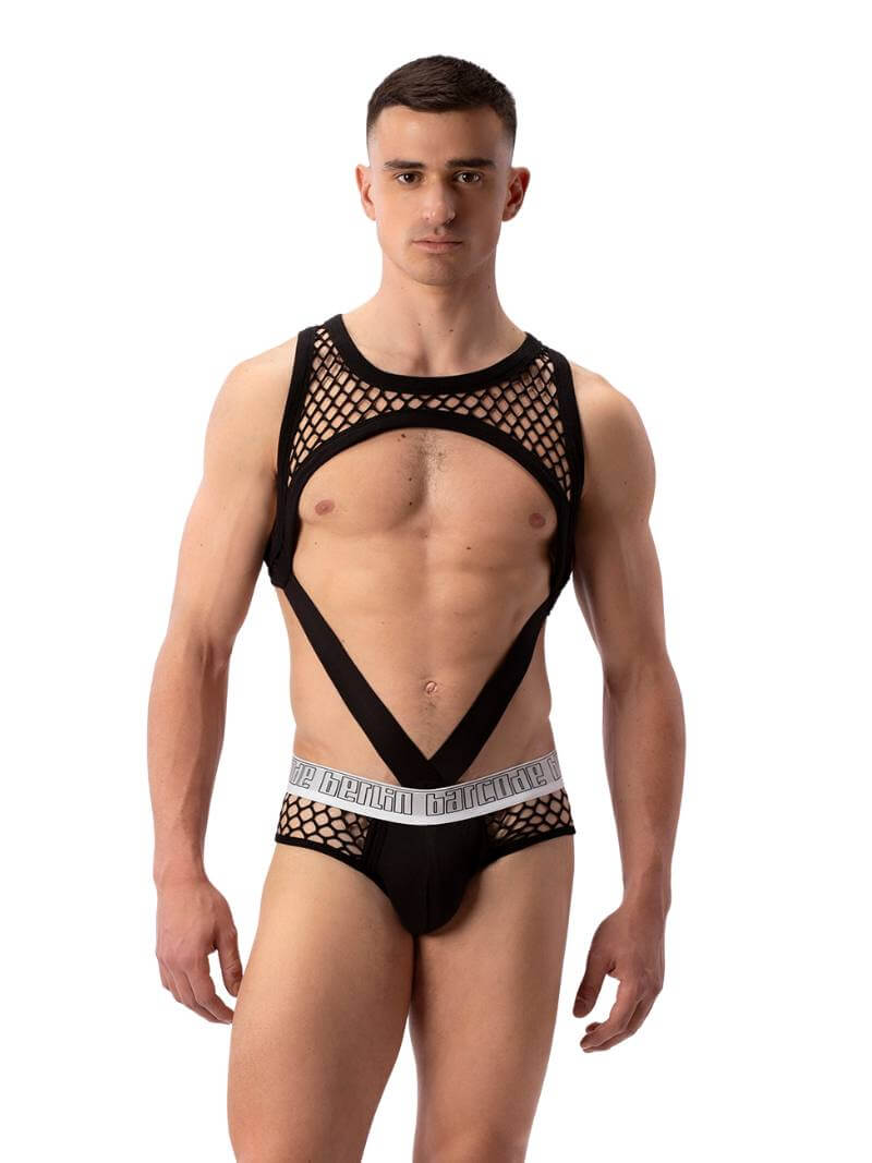 A male model wearing a purple mesh clubwear tank harness with a fishnet design.