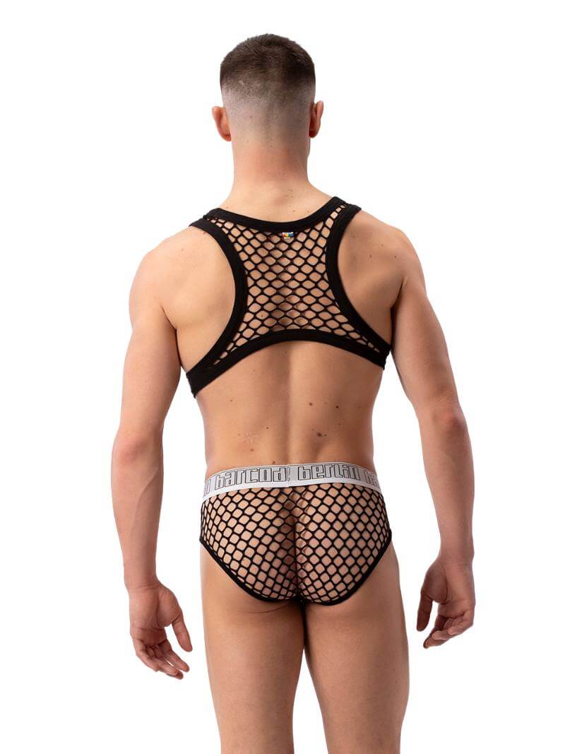 A male model wearing a purple mesh clubwear tank harness with a fishnet design.