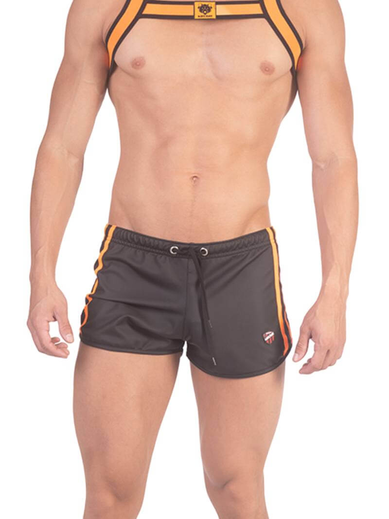 A man wearing red fishnet long-sleeve top and black mini shorts with sporty stripes and a drawstring.