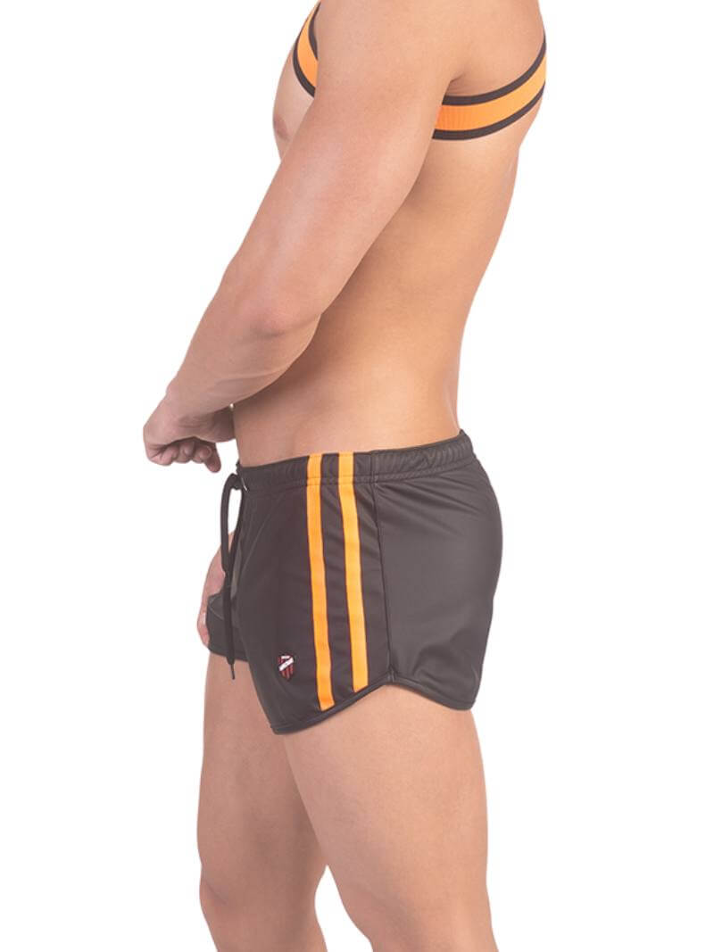 A man wearing red fishnet long-sleeve top and black mini shorts with sporty stripes and a drawstring.