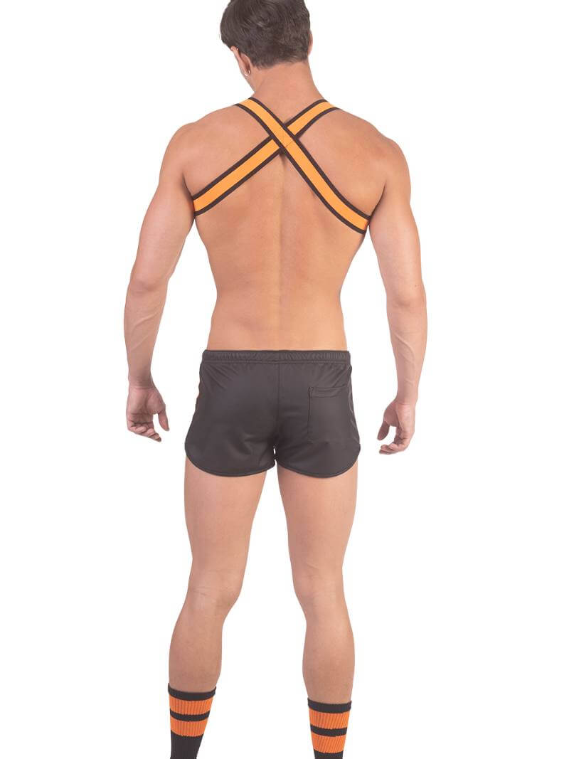 A man wearing red fishnet long-sleeve top and black mini shorts with sporty stripes and a drawstring.