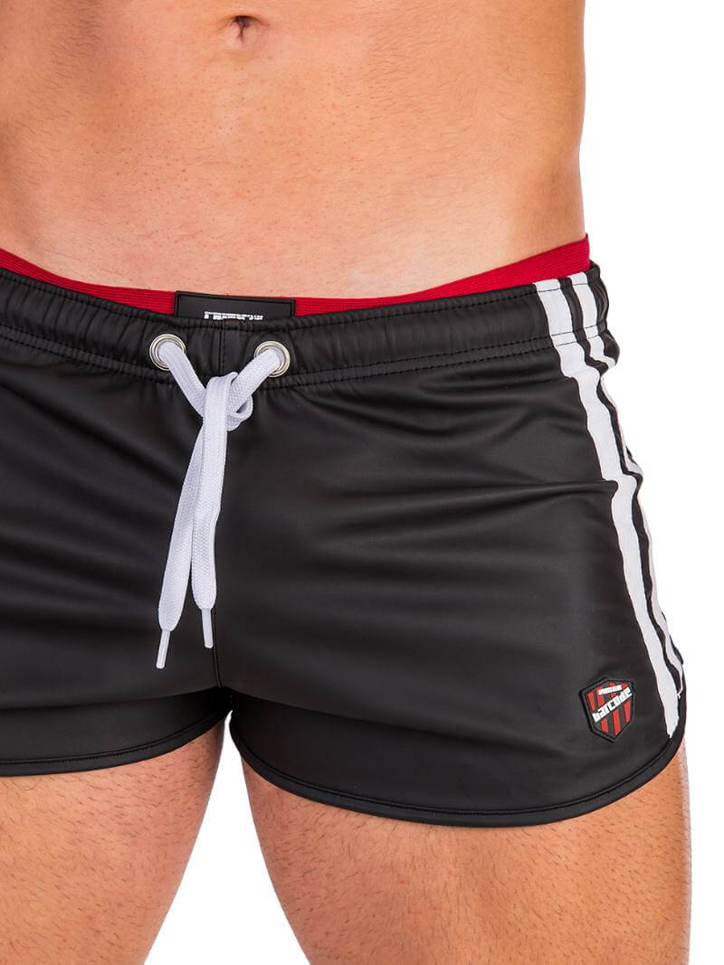 A man wearing red fishnet long-sleeve top and black mini shorts with sporty stripes and a drawstring.