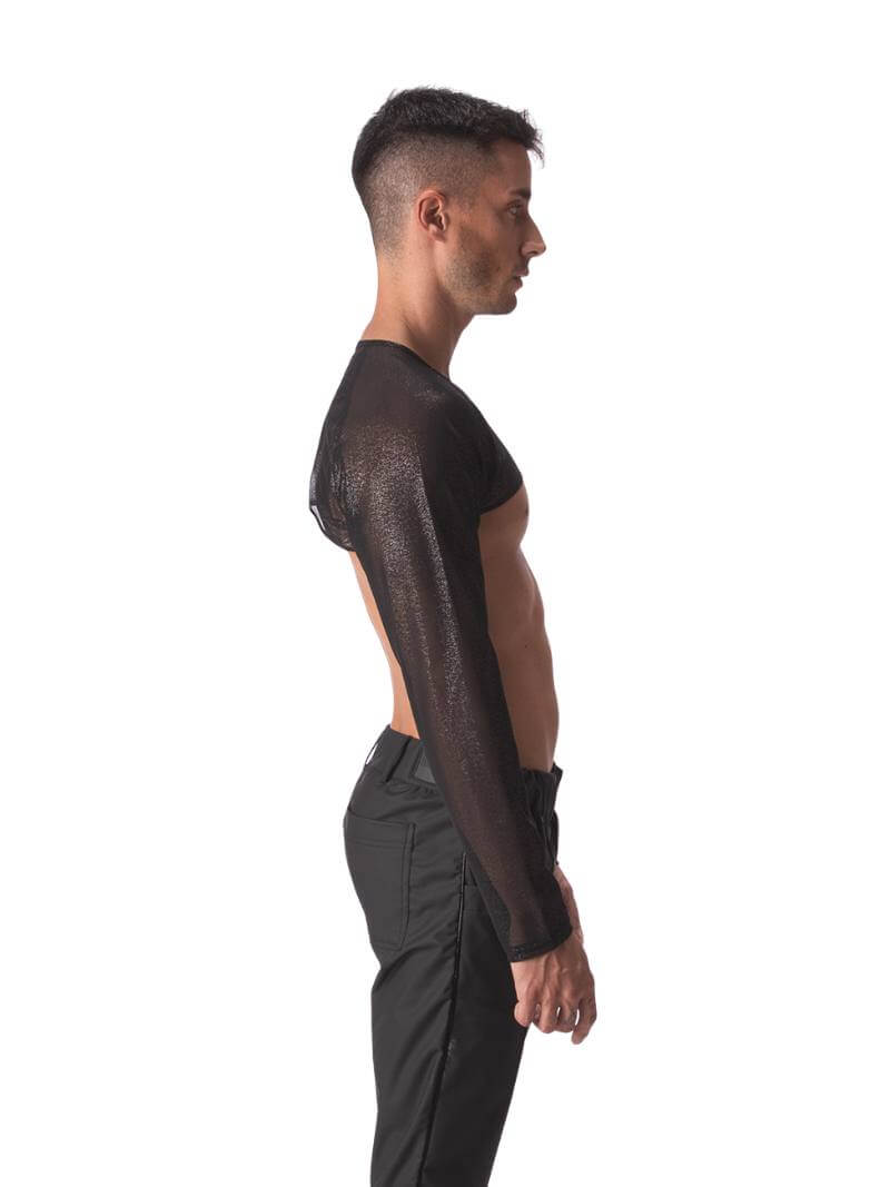 A male model wearing a black semi-see-through sheer mesh crop top with long sleeves and a v-neck.