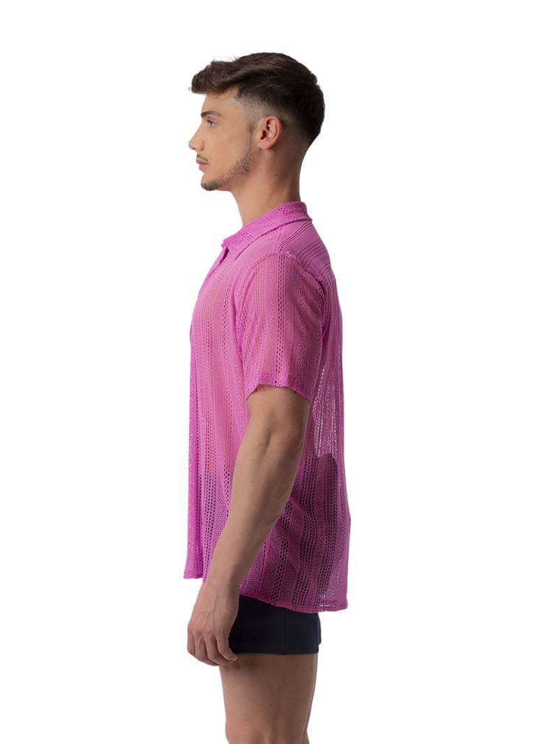A male model wearing a black, semi-see-through lace shirt with short sleeves and a collared neck.