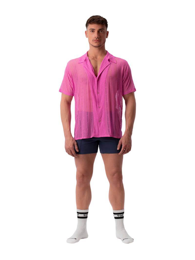 A male model wearing a black, semi-see-through lace shirt with short sleeves and a collared neck.