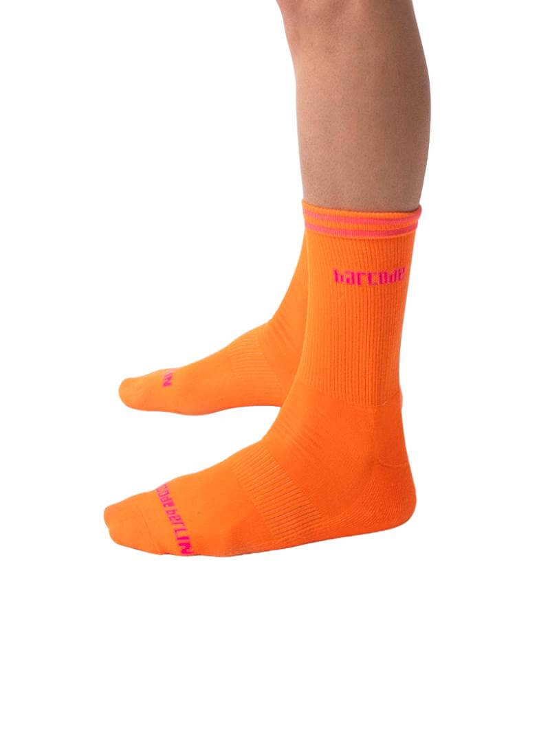 A pair of bright orange Barcode Berlin festival socks with contrasting pink and yellow stripes and the brand name on the side.