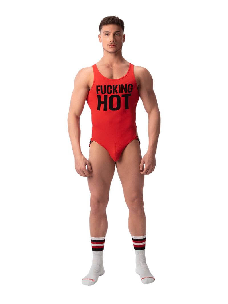 A male model wearing a red bodysuit with the text 'F**KING HOT' printed in large black letters across the chest. The bodysuit includes a contoured pouch and jockstrap at the rear with metal clip buckles.