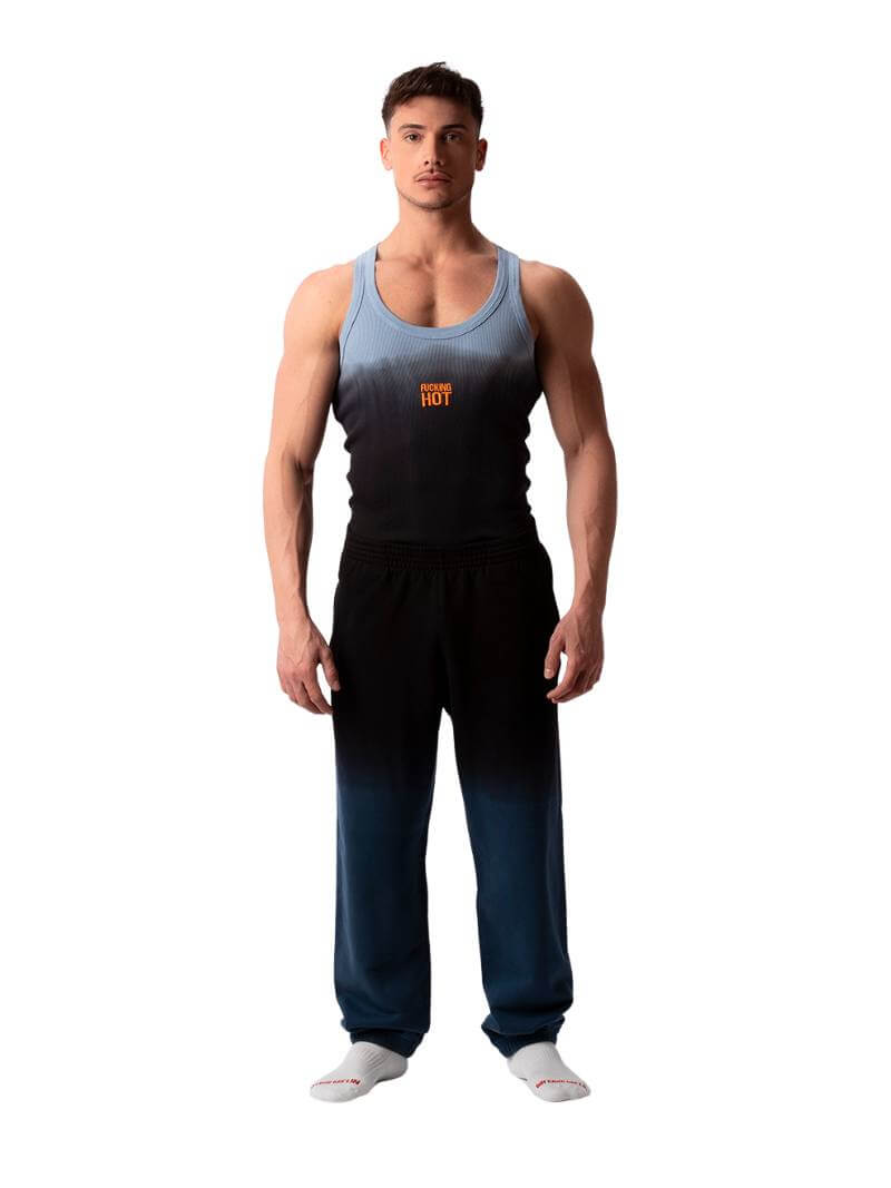 A male model wearing a sleeveless black tank top with a gradient of blue to pink and the text 'F**KING HOT' in the center, along with a 'BARCODE' branded label at the back.