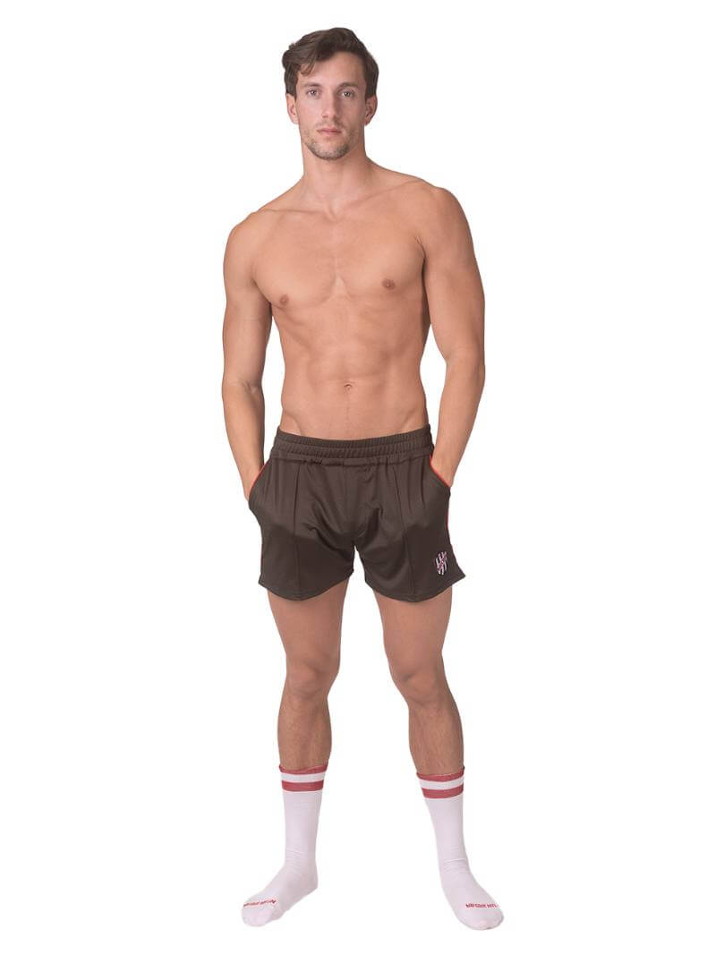 A model wearing olive green shorts with a black and white striped label and a pink top.
