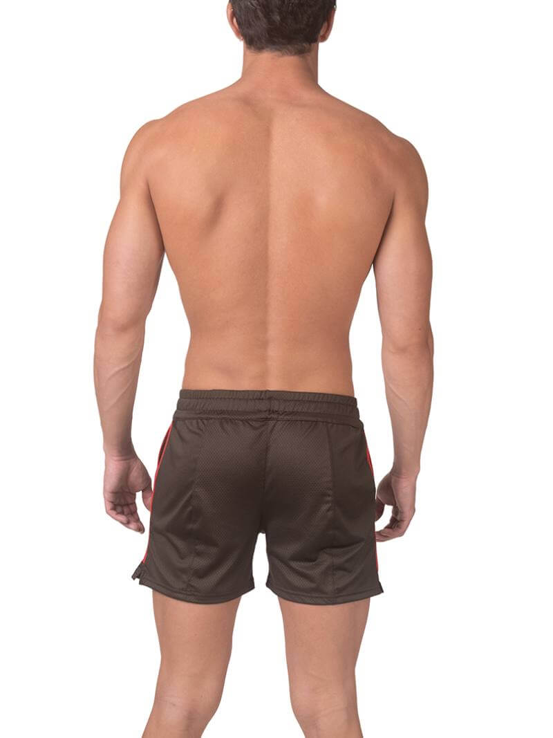 A model wearing olive green shorts with a black and white striped label and a pink top.