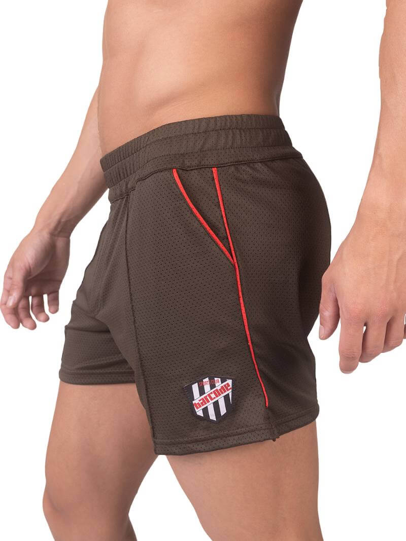 A model wearing olive green shorts with a black and white striped label and a pink top.