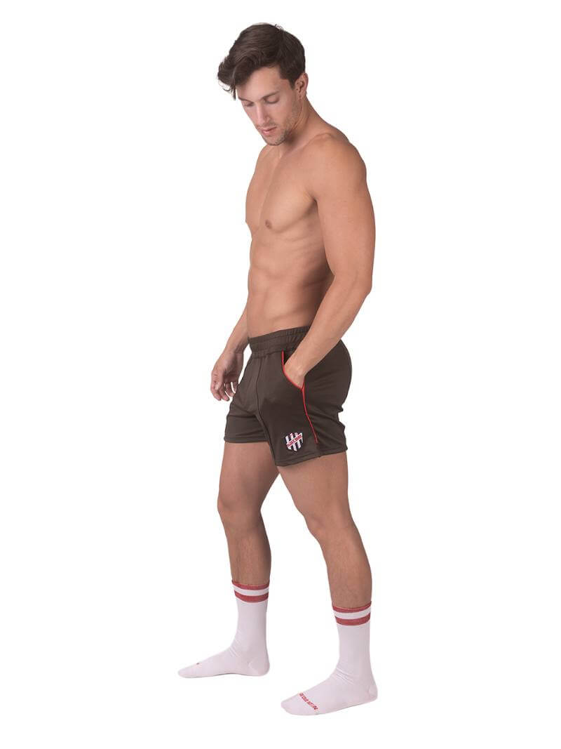 A model wearing olive green shorts with a black and white striped label and a pink top.