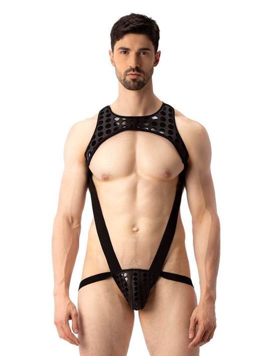 A model wearing a black and white polka dot body harness with a matching jockstrap. The harness features a chest panel, X-style back, and soft elastic straps.