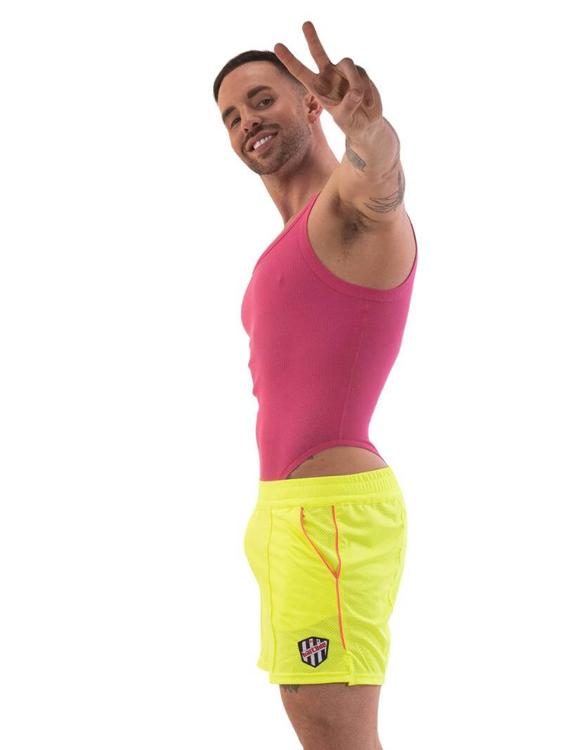 A model wearing neon pink shorts with striped label and a blue top.