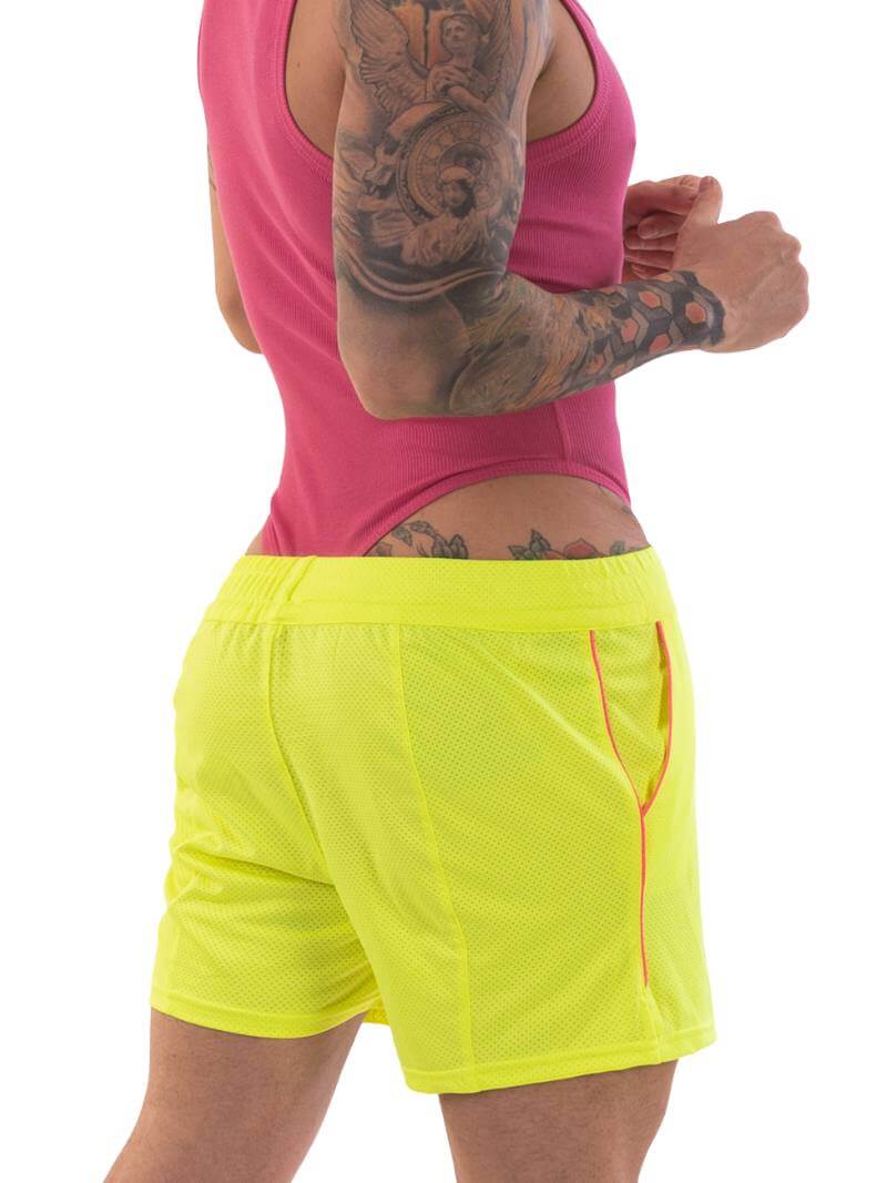 A model wearing olive green shorts with a black and white striped label and a pink top.