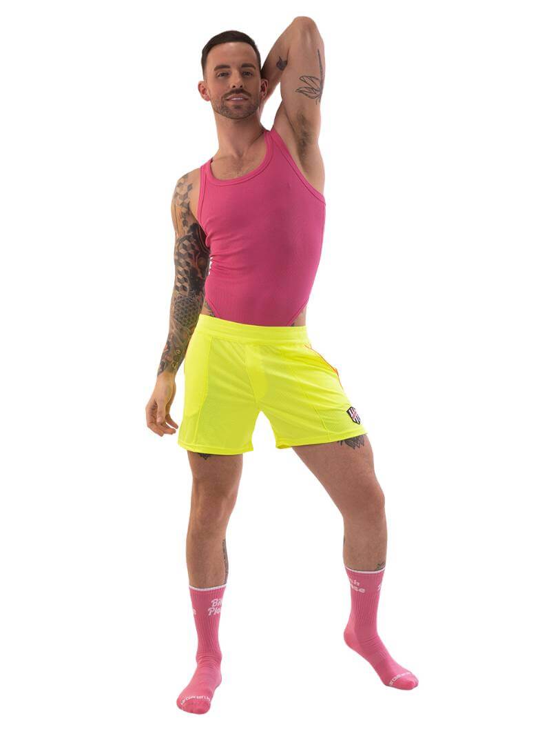 A model wearing olive green shorts with a black and white striped label and a pink top.