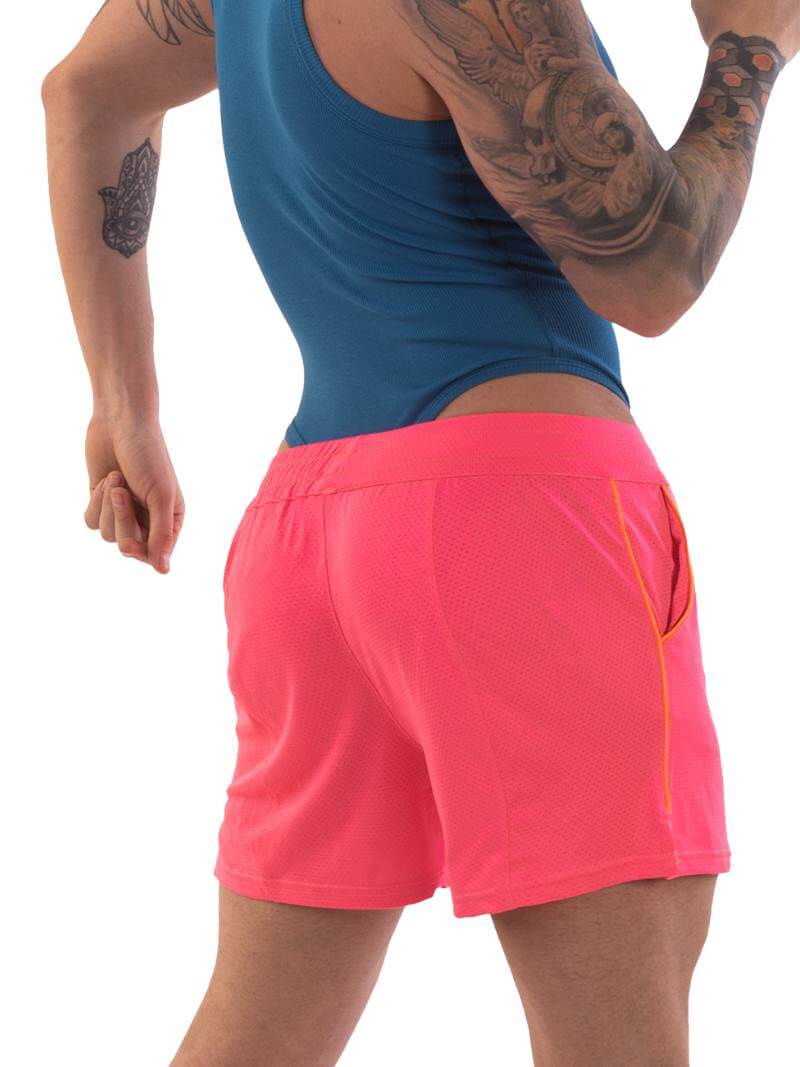 A model wearing neon pink shorts with striped label and a blue top.