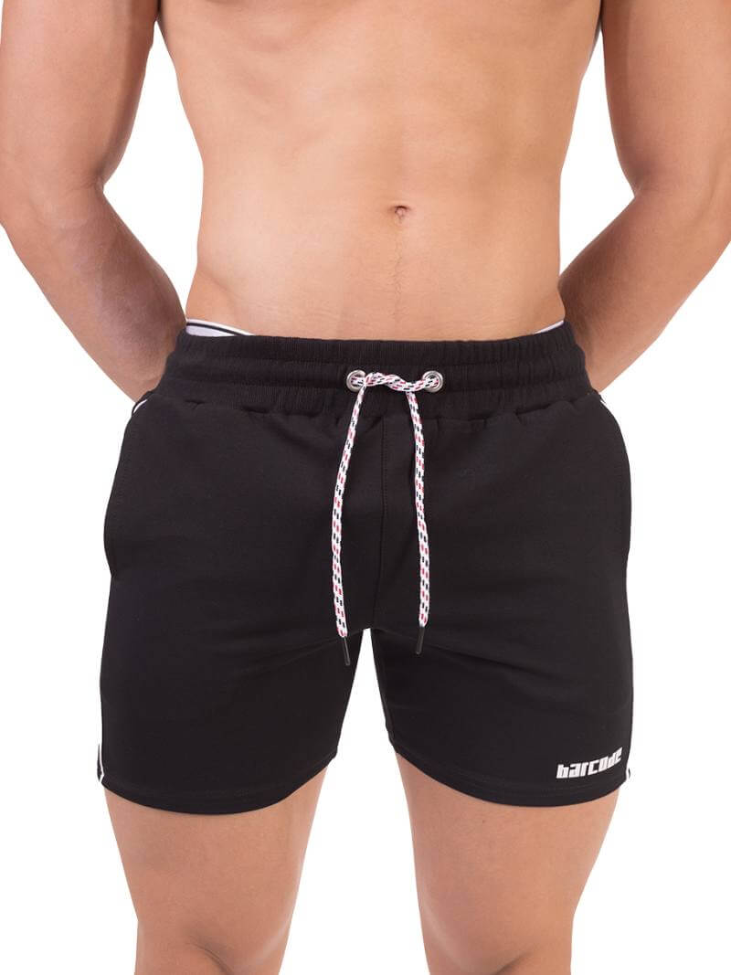 A person wearing black Barcode Berlin Lukio shorts with white trim stripes and a patterned drawstring.