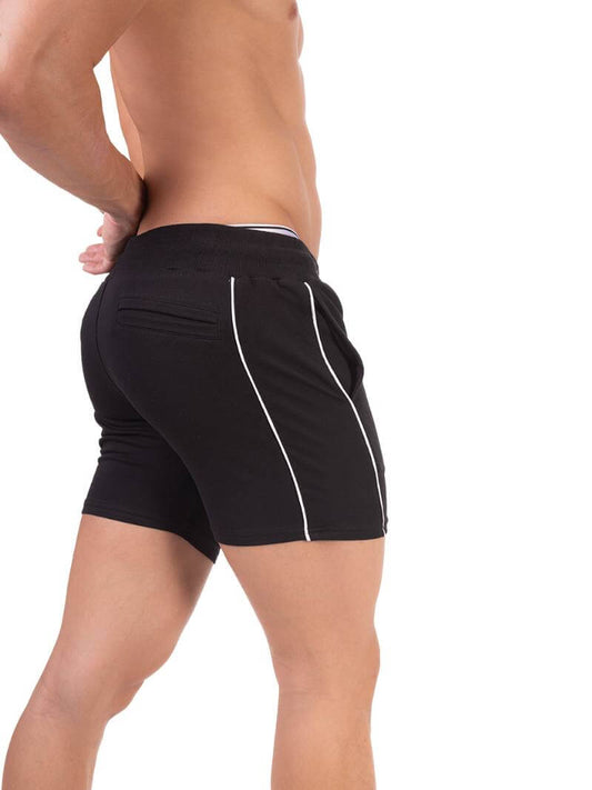 A person wearing black Barcode Berlin Lukio shorts with white trim stripes and a patterned drawstring.