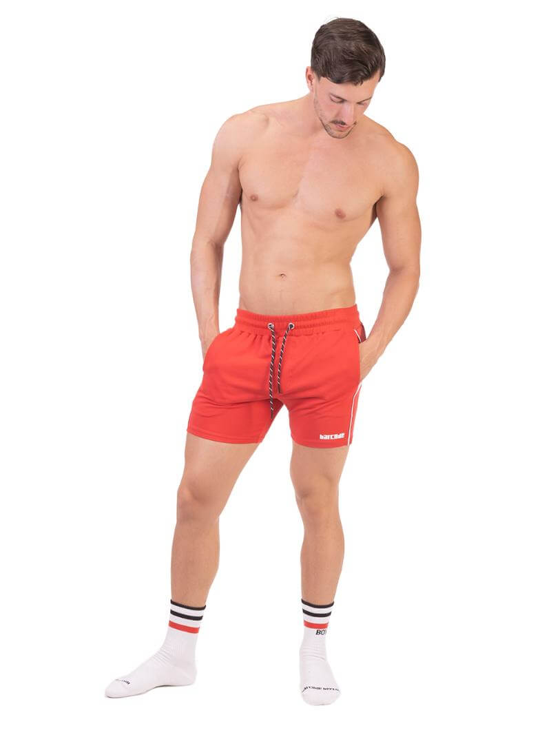 A model wearing red Barcode Berlin Lukio Casual Mid Thigh shorts with drawstring