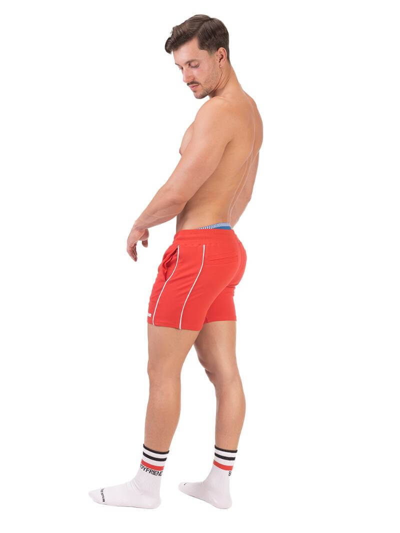 A model wearing red Barcode Berlin Lukio Casual Mid Thigh shorts with drawstring