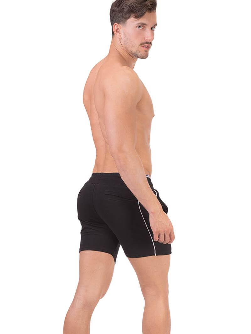 A person wearing black Barcode Berlin Lukio shorts with white trim stripes and a patterned drawstring.
