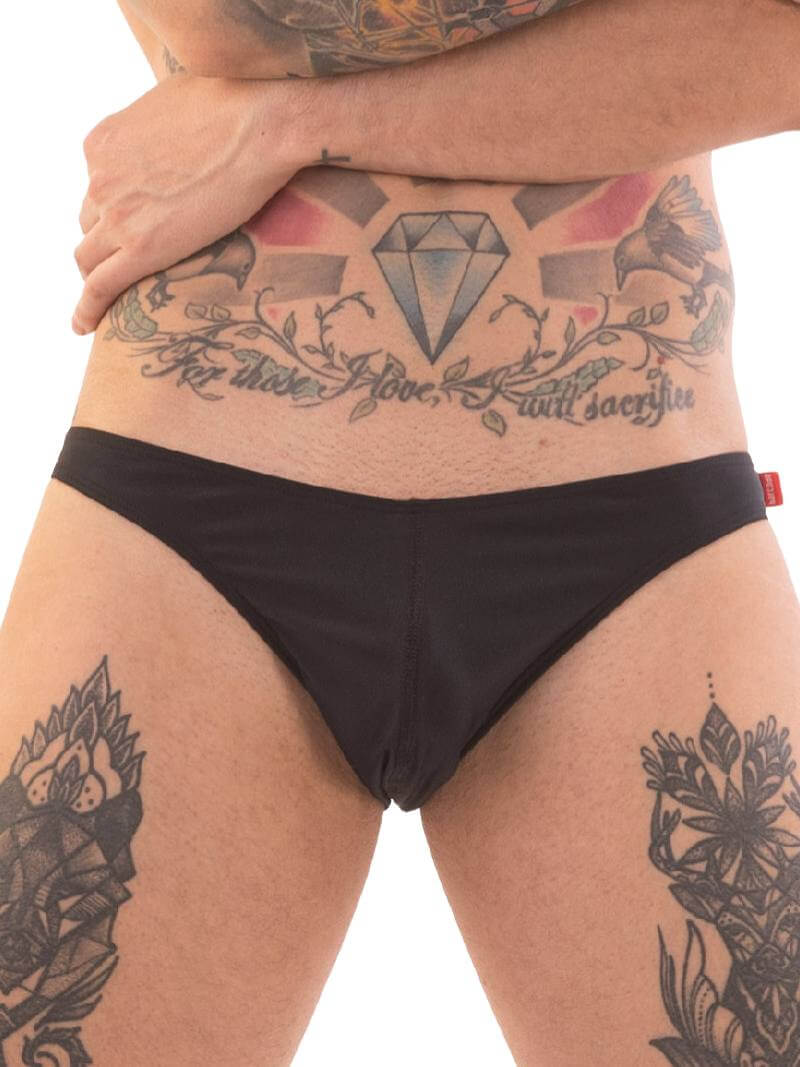 A person wearing red micro swimwear with a geometric pattern and the Barcode Berlin brand logo on the waistband.