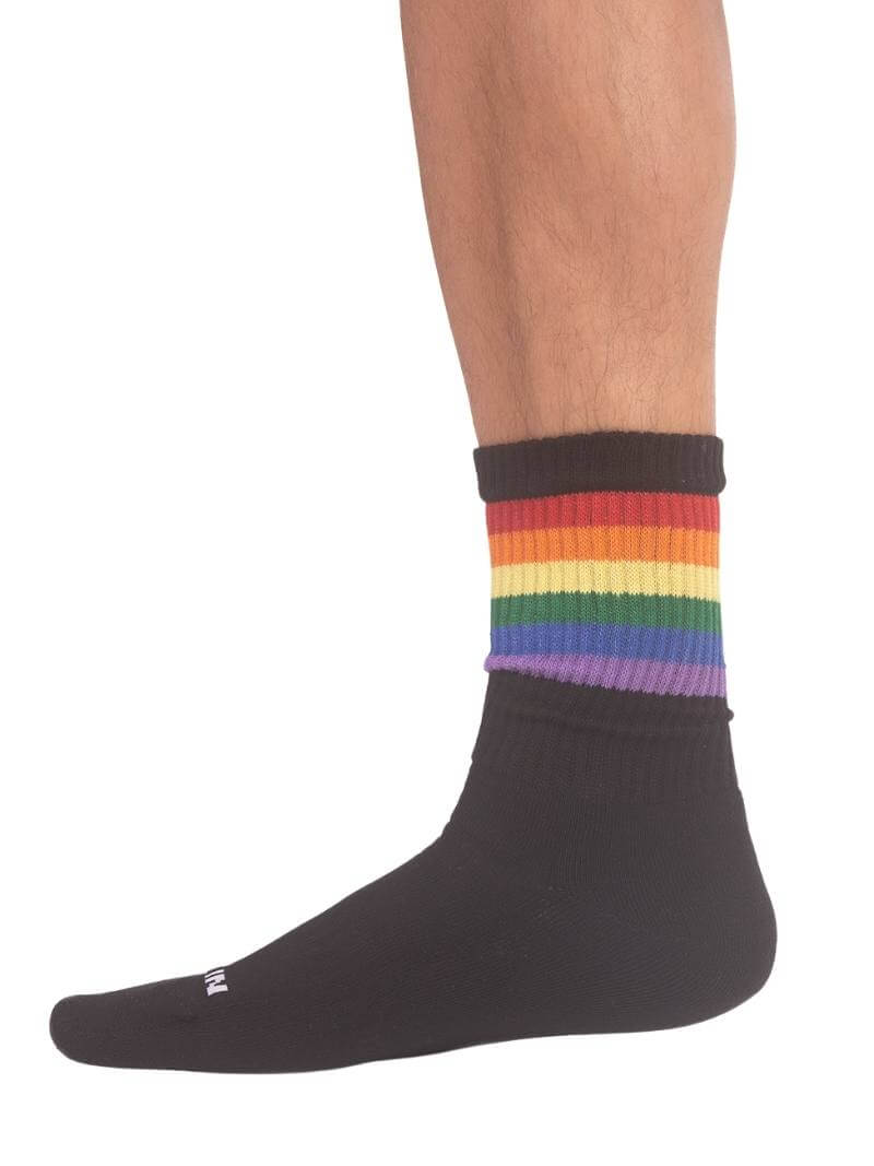 A pair of mid-calf black gym socks with colorful pride stripes on the cuff, featuring the Barcode Berlin brand logo.
