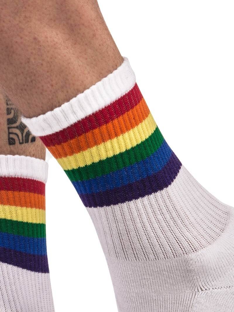 A pair of mid-calf black gym socks with colorful pride stripes on the cuff, featuring the Barcode Berlin brand logo.