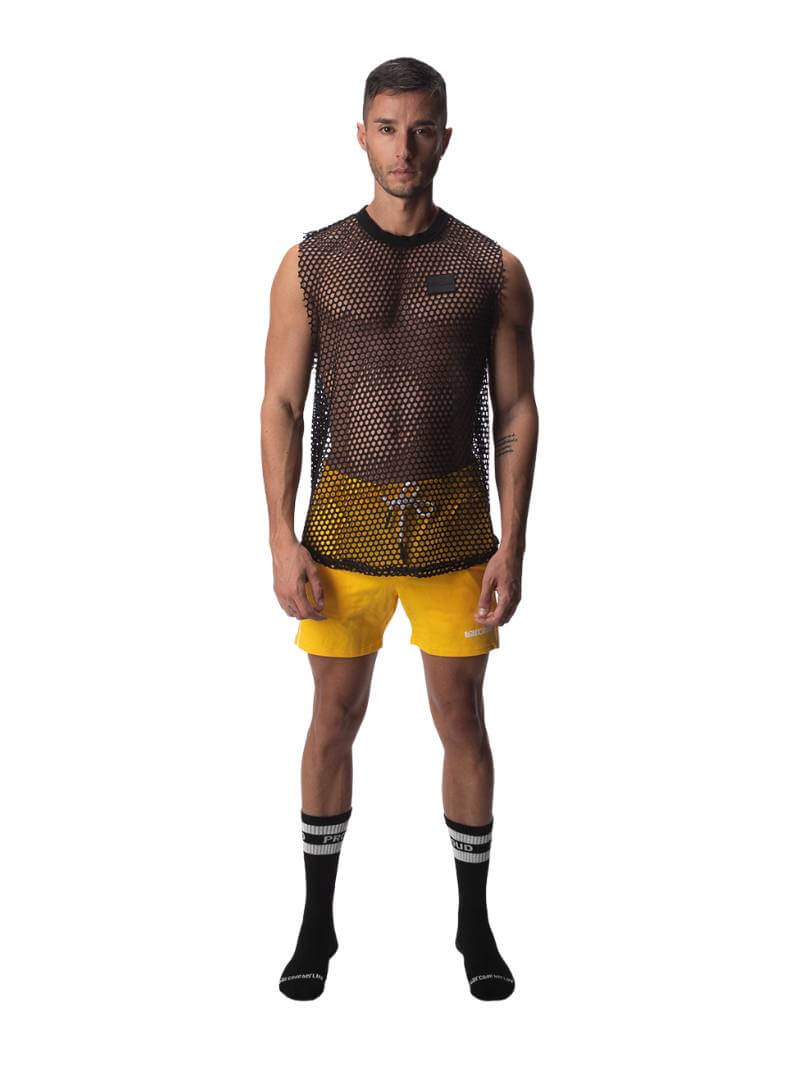 A male model wearing a black semi-see-through mesh fishnet tank top with a rounded neck and low drop armholes.