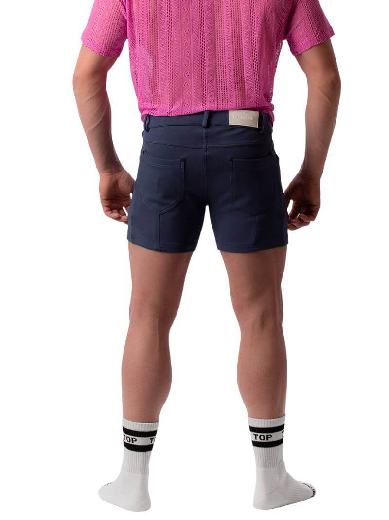 A pair of navy blue, short-leg Barcode Berlin Simon shorts with a pink, short-sleeve shirt in the background.