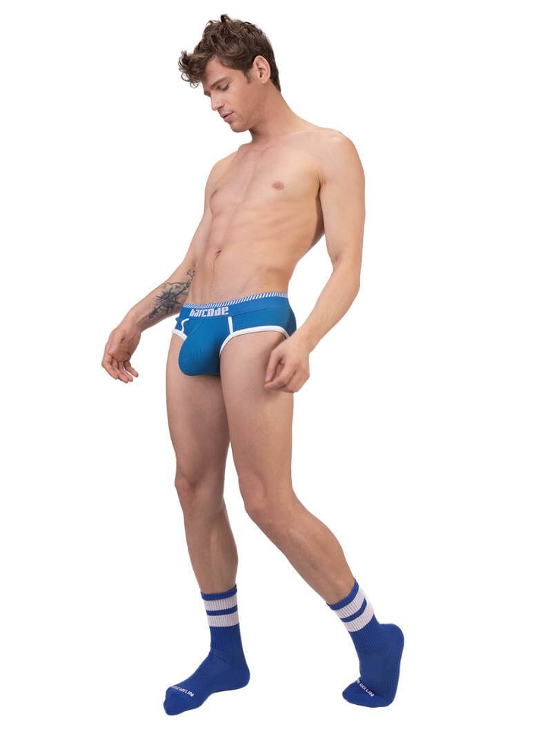 A man wearing a blue Barcode Berlin brief with white trims and a brand logo on the waistband.