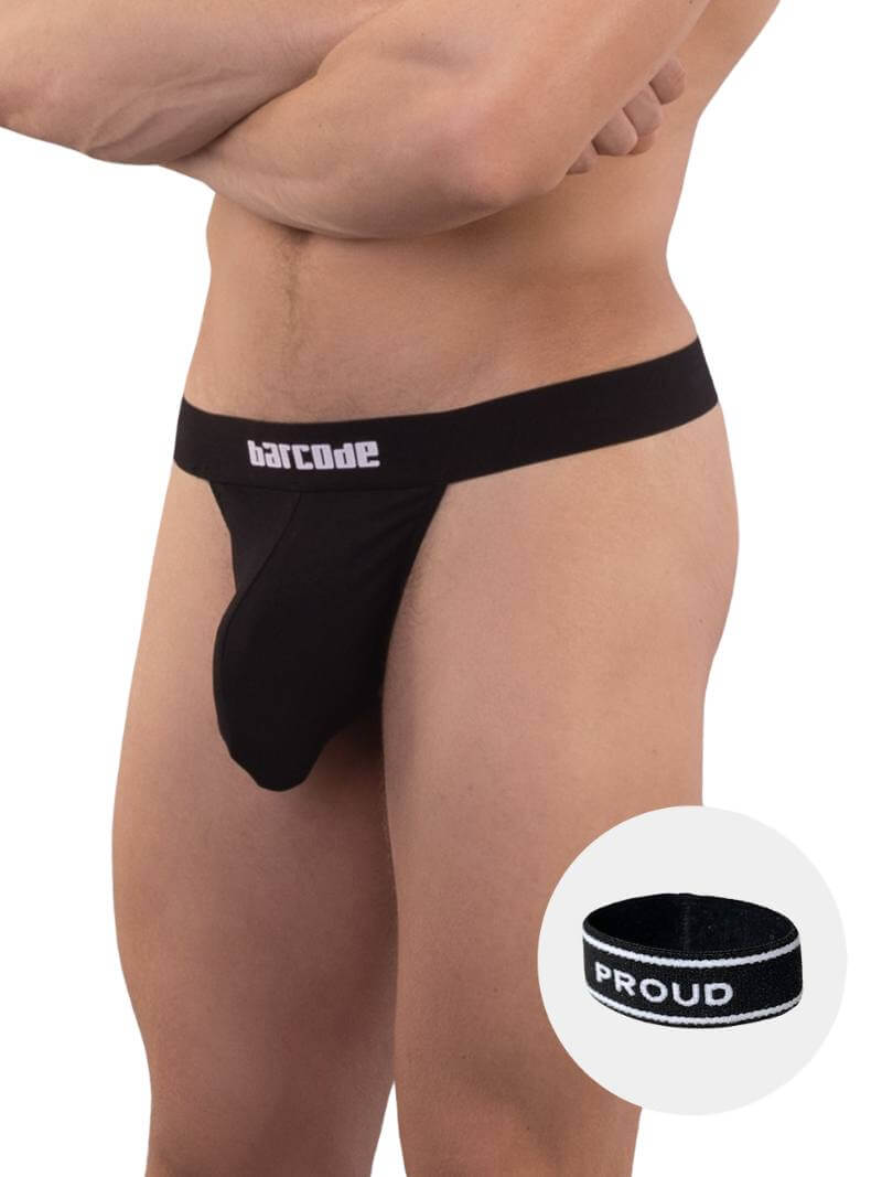 A black backless thong with Barcode branding on the waistband, featuring an elastic c-ring with 'Proud' lettering. The product is modeled by a male, showcasing the fit and design.