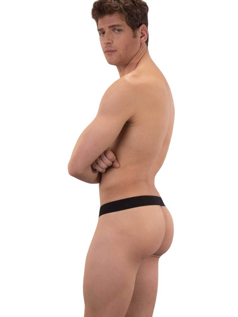 A black backless thong with Barcode branding on the waistband, featuring an elastic c-ring with 'Proud' lettering. The product is modeled by a male, showcasing the fit and design.