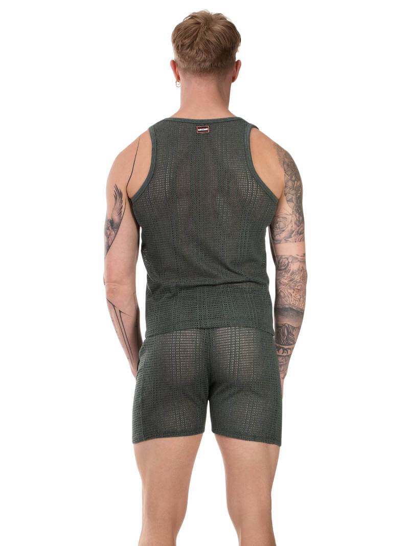 Person wearing a green mesh tank top and shorts beachwear set on a white background