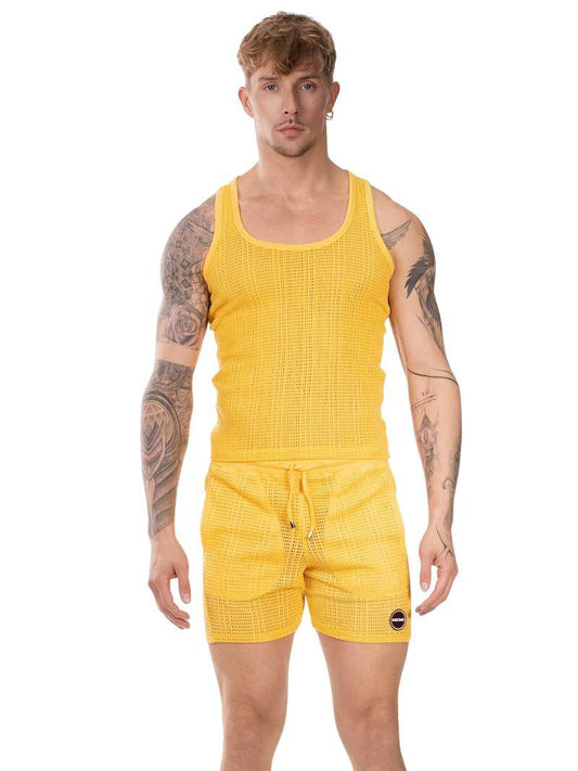Man wearing a yellow sleeveless top and shorts set on a white background