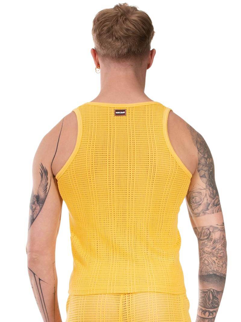 Yellow tank top worn by a person with tattoos on a white background