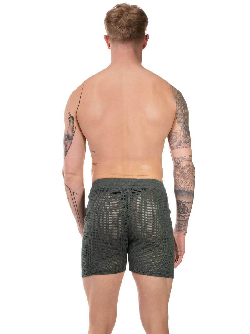 Gay guy wearing dark green see-through mesh Barcode Berlin beach shorts