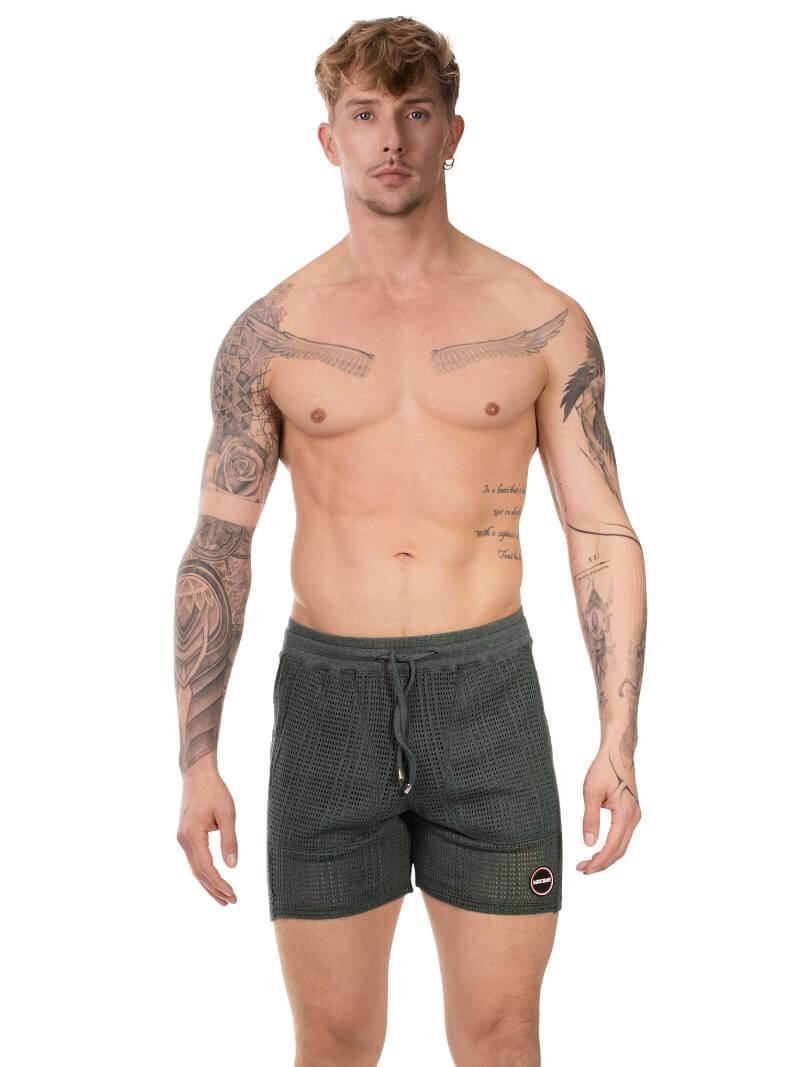 Man wearing khaki green shorts with a white background