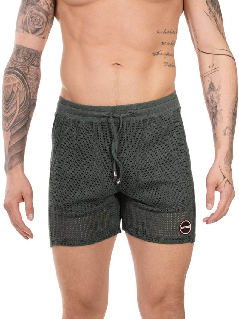 Person wearing dark green shorts with a subtle pattern on a white background