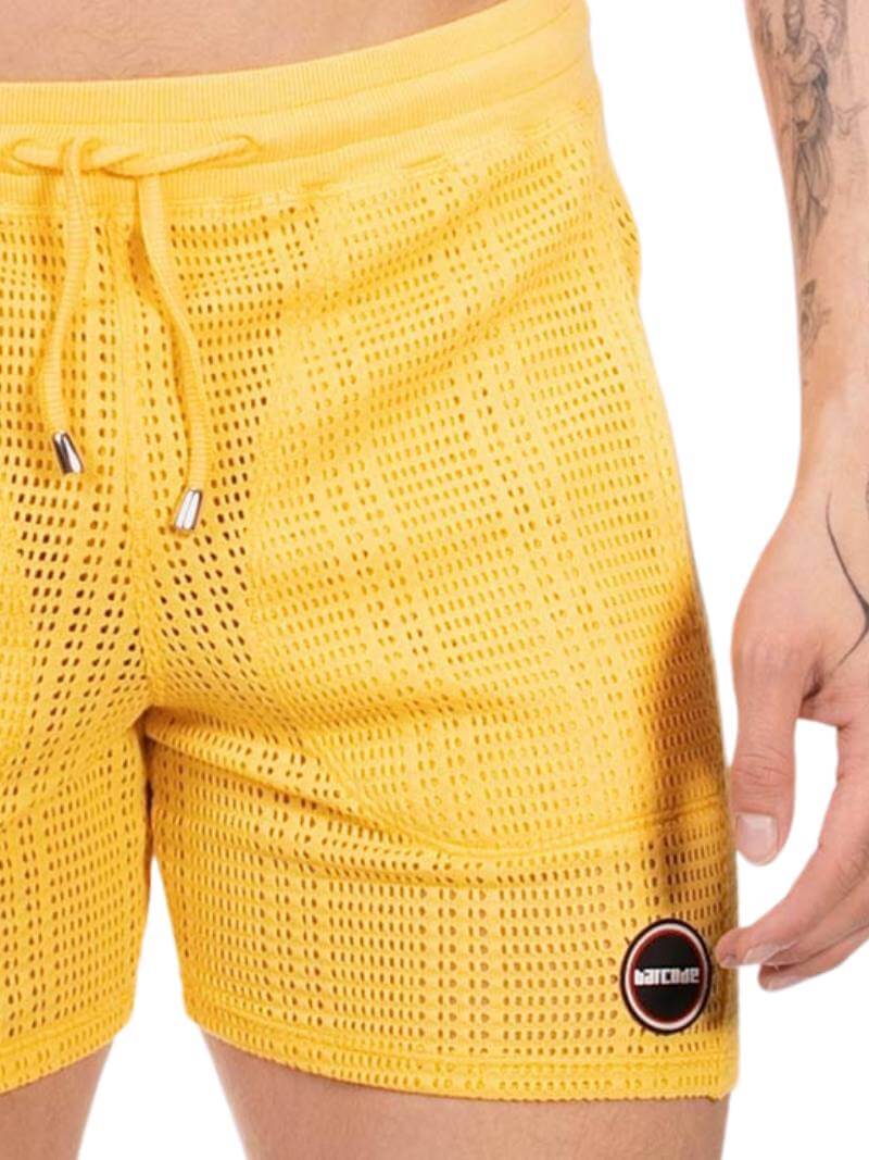 Yellow mesh shorts with a Barcode Berlin logo on a white background