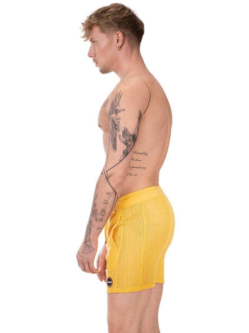 Guy wearing yellow Barcode Berlin knitted mesh shorts