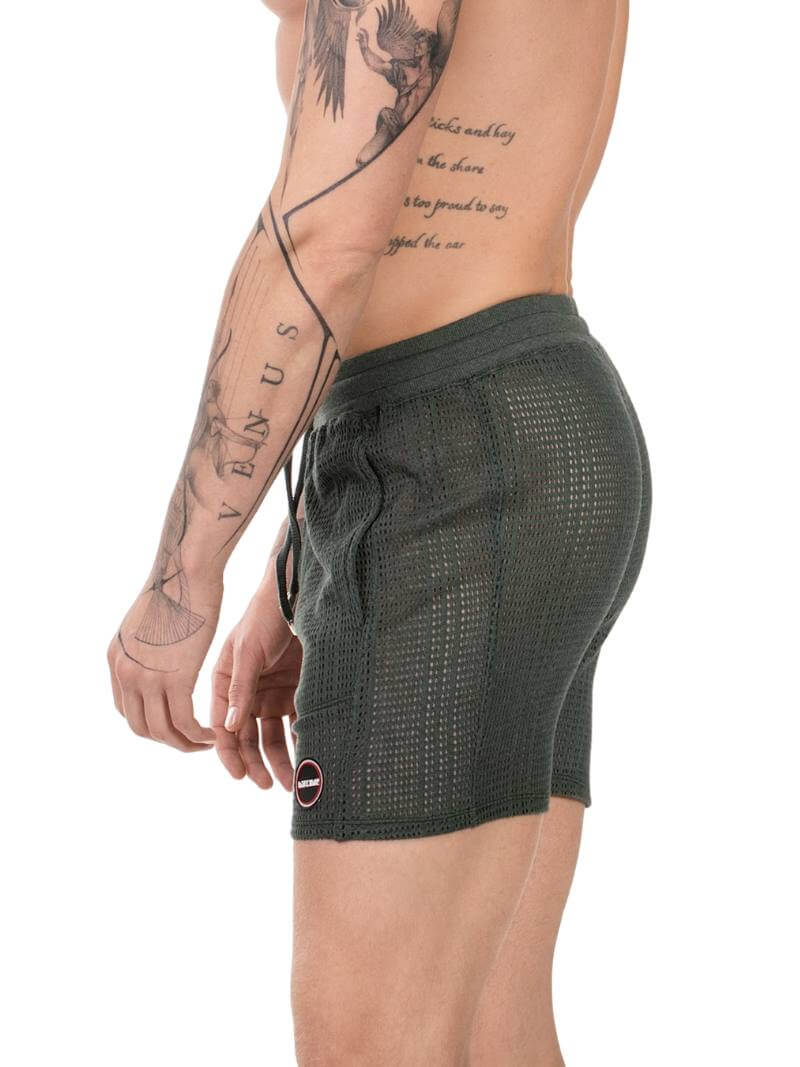 Person wearing dark green shorts with a white background